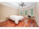 Bedroom with hardwood floors, tray ceiling, and natural light from large windows at 925 Giacomo Dr, Waxhaw, NC 28173