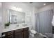 Bright bathroom with a dark wood vanity, white countertop, large mirror, and a shower tub combo at 990 Nw Capwalk Nw Rd # 138, Concord, NC 28027