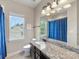 Bright bathroom featuring granite counters, a modern vanity, and a large mirror reflecting natural light at 10716 Meg Meadow Dr, Mint Hill, NC 28227