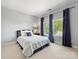 Cozy bedroom with a comfortable bed, bedside table, and natural light streaming through the window at 10716 Meg Meadow Dr, Mint Hill, NC 28227