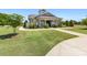 Low-angle day shot of the neighborhood clubhouse with a sidewalk and well-manicured landscaping at 10716 Meg Meadow Dr, Mint Hill, NC 28227