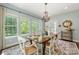 Dining room with a view to the backyard, hardwood floors, and a decorative chandelier at 10716 Meg Meadow Dr, Mint Hill, NC 28227