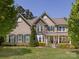 Beautiful two-story home with a stone facade, covered porch, manicured lawn, and mature trees at 10716 Meg Meadow Dr, Mint Hill, NC 28227