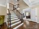 Elegant foyer with a staircase, hardwood floors, and an office space visible in the background at 10716 Meg Meadow Dr, Mint Hill, NC 28227