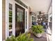 Inviting front porch with a dark wood door, neutral siding, and comfortable seating area at 10716 Meg Meadow Dr, Mint Hill, NC 28227