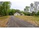Stunning single-story home with a long driveway and lush greenery surrounding the property at 108 Woodwinds St, Locust, NC 28097