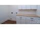 Clean laundry room with modern white cabinets and butcher block countertop at 108 Woodwinds St, Locust, NC 28097