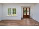 Bright living room showcasing hardwood floors, a large window, and stylish doors, creating an inviting space at 108 Woodwinds St, Locust, NC 28097