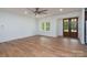 Expansive living room featuring an open layout, wood flooring, large windows, and modern ceiling fan at 108 Woodwinds St, Locust, NC 28097
