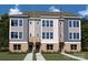 Modern townhome exterior with brick base, large windows, and neutral-toned siding at 1112 Bismuth Ln, Charlotte, NC 28211