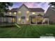 Well-manicured backyard featuring a covered patio, lush lawn, and outdoor entertainment area at 125 N Wendover Trce, Mooresville, NC 28117