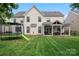 A large backyard with a covered patio, lush green lawn, and recreational amenities at 125 N Wendover Trce, Mooresville, NC 28117