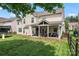 Spacious backyard featuring a covered patio, lush lawn, and recreational equipment at 125 N Wendover Trce, Mooresville, NC 28117
