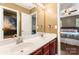 Bathroom featuring double vanity, cherry cabinets, large mirror, and views of the bedroom at 125 N Wendover Trce, Mooresville, NC 28117