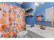 Charming bathroom featuring an orange patterned shower curtain, decorative shelves, and blue painted walls at 125 N Wendover Trce, Mooresville, NC 28117