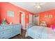 Bright bedroom featuring wood floors, vibrant coral walls, and well-lit space at 125 N Wendover Trce, Mooresville, NC 28117