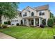 Charming two-story home featuring a manicured lawn and inviting front porch with classic columns at 125 N Wendover Trce, Mooresville, NC 28117