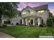 Charming two-story home featuring a manicured lawn and inviting front porch with classic columns at 125 N Wendover Trce, Mooresville, NC 28117