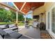 Covered patio with an outdoor kitchen, stylish furniture, and view of the spacious backyard at 125 N Wendover Trce, Mooresville, NC 28117