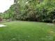 A large, grassy backyard with mature trees and a wood fence at 13237 Fremington Rd, Huntersville, NC 28078