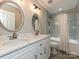 A bathroom features dual sinks with bright lighting and a shower-tub combo at 13237 Fremington Rd, Huntersville, NC 28078