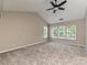 A spacious bedroom features a ceiling fan, natural light, and neutral carpet and paint at 13237 Fremington Rd, Huntersville, NC 28078