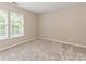 This bedroom features natural light with neutral carpet and paint at 13237 Fremington Rd, Huntersville, NC 28078