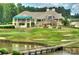 Picturesque golf course view with a clubhouse, sand traps, putting green, and a scenic pond at 13237 Fremington Rd, Huntersville, NC 28078
