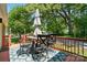Relaxing back deck with outdoor seating, a shady umbrella, and serene views of the surrounding trees at 139 5Th St, Huntersville, NC 28078