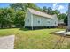Exterior shot of home showcasing large backyard with expansive grassy area, landscaping, and mature trees at 139 5Th St, Huntersville, NC 28078