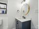 Modern half bathroom featuring sleek vanity and round mirror at 139 5Th St, Huntersville, NC 28078