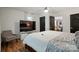Spacious main bedroom with a ceiling fan, tv, and dark accent doors is adjacent to the living room at 139 5Th St, Huntersville, NC 28078