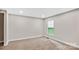 Neutrally painted bedroom featuring wall-to-wall carpeting, a window for natural light, and modern baseboards at 143 Phifer Cir, Kings Mountain, NC 28086