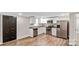 Modern kitchen featuring stainless steel appliances, white cabinets, granite countertops, and wood-look flooring at 143 Phifer Cir, Kings Mountain, NC 28086