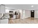 Open kitchen with stainless steel refrigerator, granite countertops, white cabinets, and wood-look flooring at 143 Phifer Cir, Kings Mountain, NC 28086
