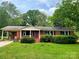 Charming single-story red brick home with a well-manicured green lawn and lush landscaping at 1824 Ebinport Rd, Rock Hill, SC 29732
