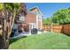 Backyard featuring a well-manicured lawn, brick house, patio furniture, and wooden fence providing privacy at 18524 Mizzenmast Ave, Cornelius, NC 28031