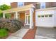 Inviting brick home with a cozy front porch, manicured landscaping, and attached two-car garage at 18524 Mizzenmast Ave, Cornelius, NC 28031
