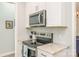 Modern kitchen featuring stainless appliances, granite counters, and stylish tile backsplash at 18524 Mizzenmast Ave, Cornelius, NC 28031