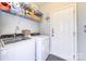 Functional laundry room with modern appliances, storage shelves, and easy access to the home's exterior at 18524 Mizzenmast Ave, Cornelius, NC 28031