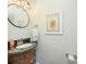 Elegant powder room with a stylish vanity, decorative mirror, and charming artwork adding a touch of sophistication at 18524 Mizzenmast Ave, Cornelius, NC 28031