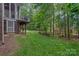 Backyard view showcasing a deck, lush lawn, and mature trees, creating a private oasis at 202 Whitmyre Ct, Fort Mill, SC 29715