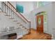 Grand foyer featuring a wooden staircase, hardwood floors, and decorative front door at 202 Whitmyre Ct, Fort Mill, SC 29715
