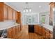 Bright kitchen boasts wooden cabinets, quartz countertops, and an adjacent dining area with natural light at 202 Whitmyre Ct, Fort Mill, SC 29715