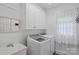 Well-lit laundry room with white cabinets, modern washer and dryer, and a utility sink at 202 Whitmyre Ct, Fort Mill, SC 29715