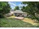 A backyard featuring a wood deck, with chairs and grill outside of the white vinyl-sided house at 228 Grayland Rd, Mooresville, NC 28115