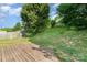 View of the spacious backyard featuring a wood deck, grassy area and mature tree providing lots of shade at 228 Grayland Rd, Mooresville, NC 28115