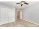 A simple bedroom with neutral carpet, white closet doors, and an adjoining hallway at 228 Grayland Rd, Mooresville, NC 28115