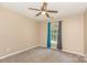 A simple bedroom with neutral carpet, a window, and blue curtains at 228 Grayland Rd, Mooresville, NC 28115