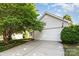 Exterior garage with white siding, mature landscaping and a lovely shade tree at 228 Grayland Rd, Mooresville, NC 28115